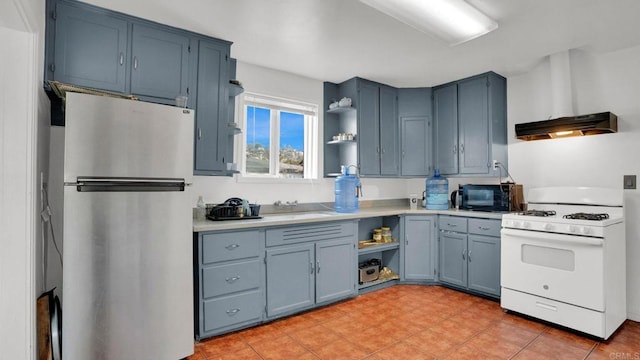 kitchen featuring blue cabinetry, stainless steel fridge, extractor fan, and gas range gas stove