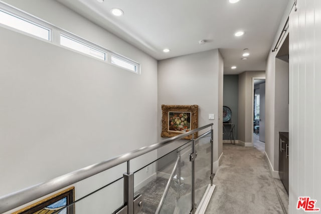 hallway with a healthy amount of sunlight and light colored carpet