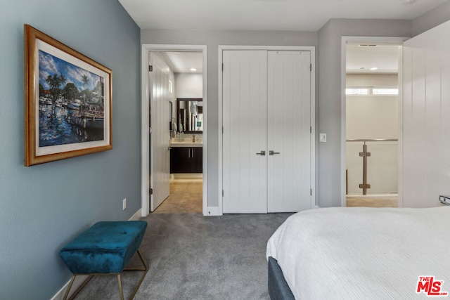 bedroom featuring dark colored carpet, ensuite bathroom, and a closet