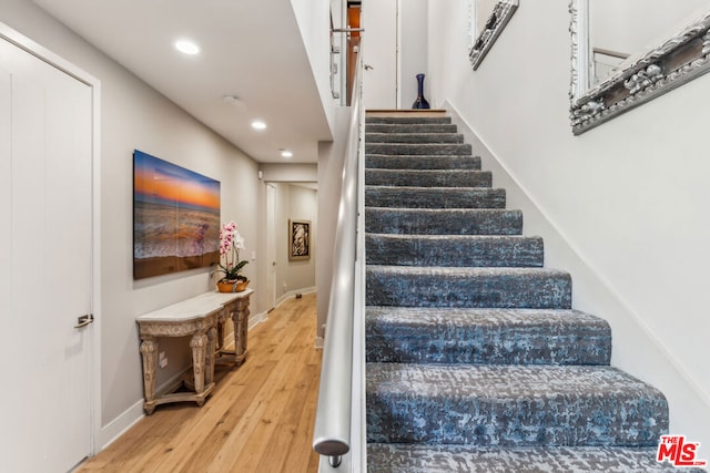 staircase with wood-type flooring