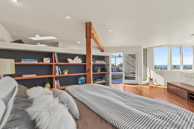 bedroom with beam ceiling, hardwood / wood-style floors, and multiple windows