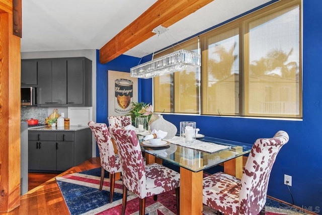 dining space featuring beam ceiling and dark hardwood / wood-style floors