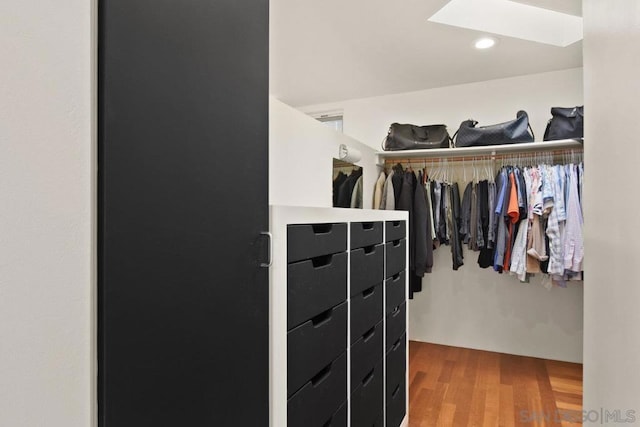 walk in closet with hardwood / wood-style flooring and a skylight