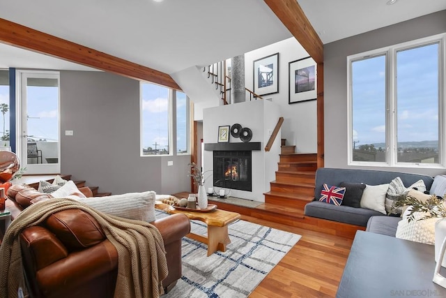 living room with beamed ceiling and light wood-type flooring