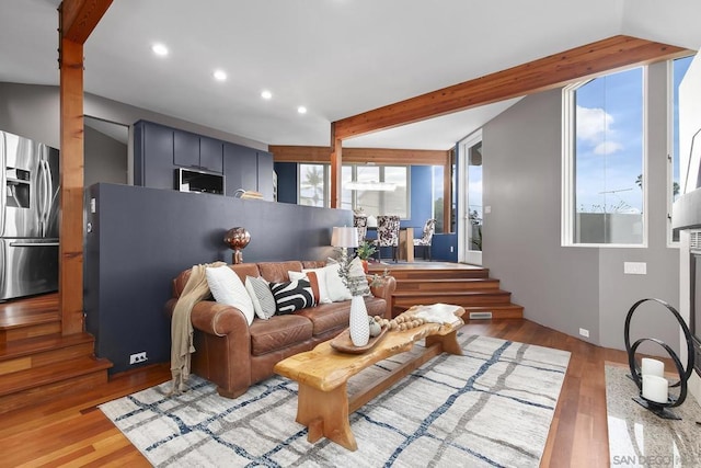 living room with beamed ceiling and light wood-type flooring