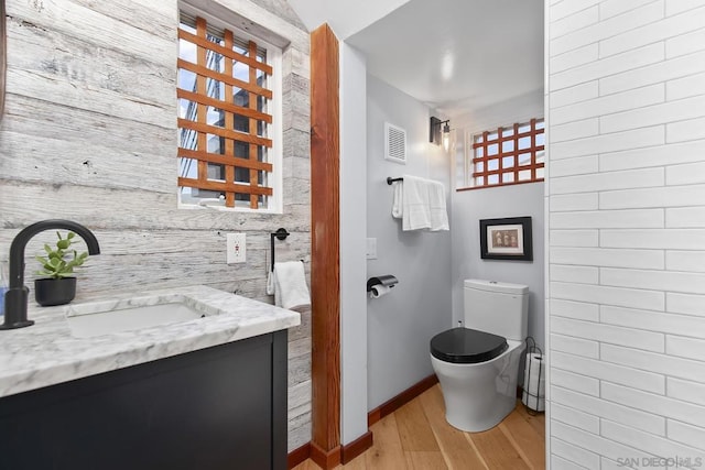 bathroom featuring hardwood / wood-style flooring, vanity, and toilet