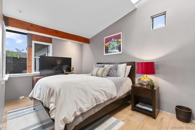 bedroom with lofted ceiling, multiple windows, and light hardwood / wood-style flooring