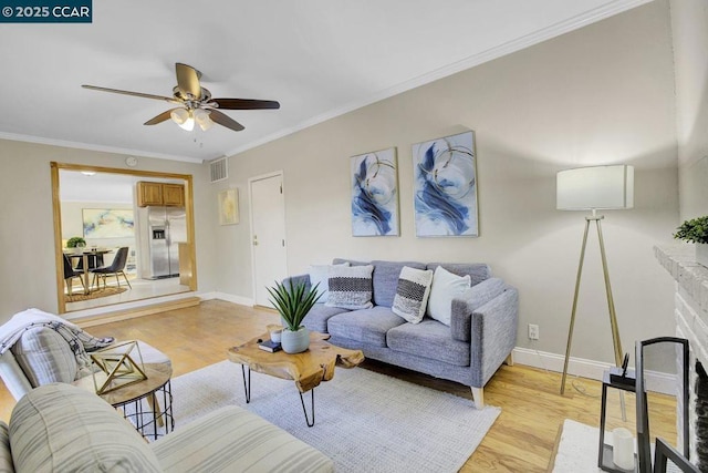 living room with crown molding, ceiling fan, and light wood-type flooring