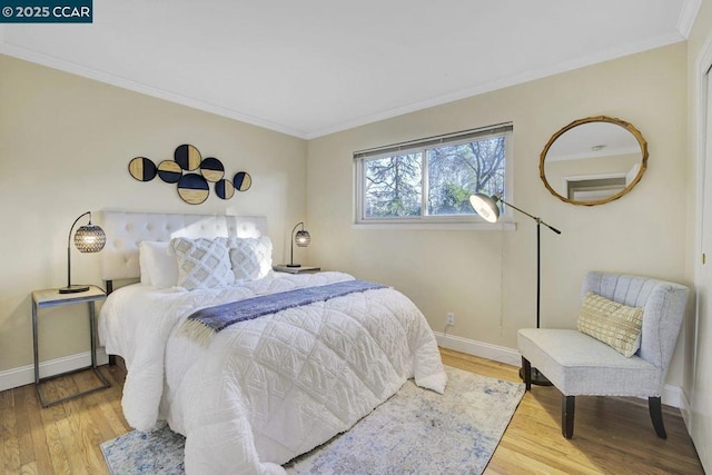 bedroom with hardwood / wood-style flooring and crown molding