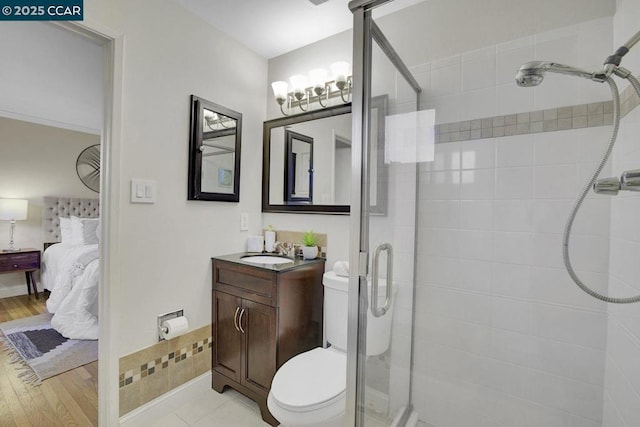 bathroom featuring vanity, toilet, and a shower with door