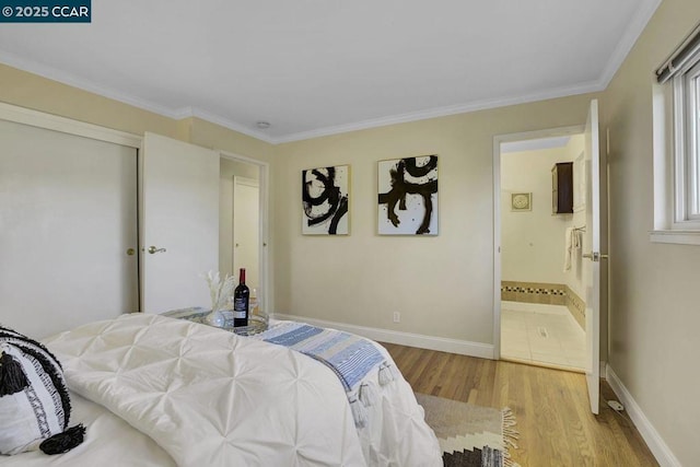 bedroom with crown molding, ensuite bath, light hardwood / wood-style floors, and a closet