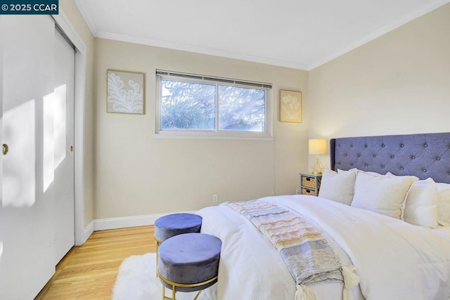 bedroom featuring crown molding, light hardwood / wood-style floors, and a closet