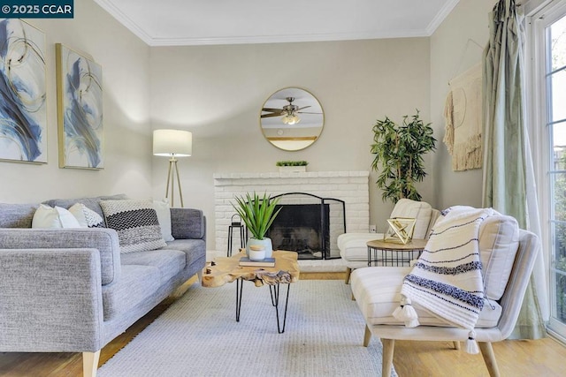 living room featuring crown molding, hardwood / wood-style floors, and a fireplace