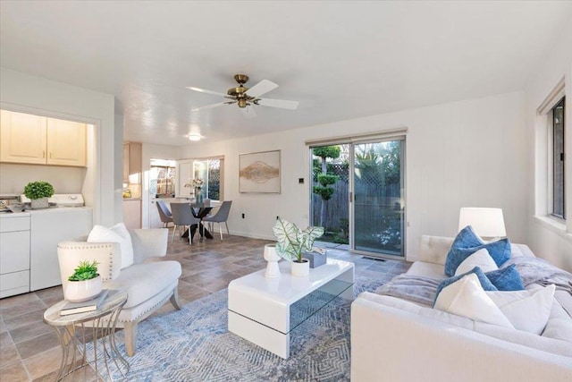 living room with ceiling fan and independent washer and dryer