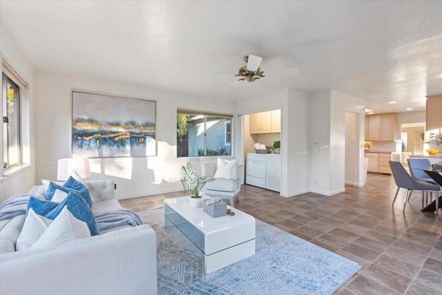 living room with ceiling fan and separate washer and dryer