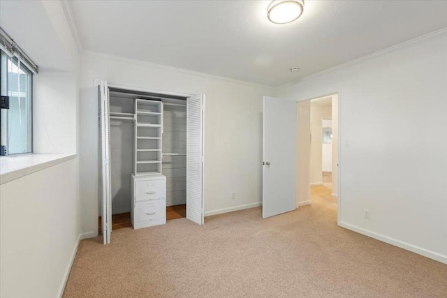 unfurnished bedroom with ornamental molding, light colored carpet, and a closet