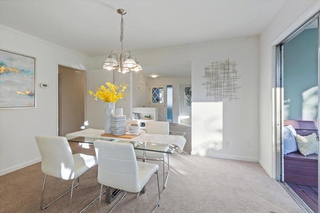 carpeted dining area featuring crown molding and a chandelier