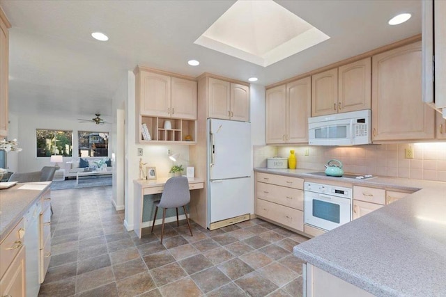 kitchen featuring light brown cabinetry and white appliances