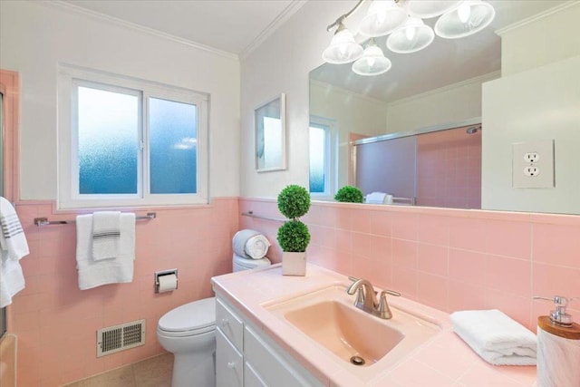 bathroom featuring a shower with shower door, tile walls, ornamental molding, vanity, and toilet