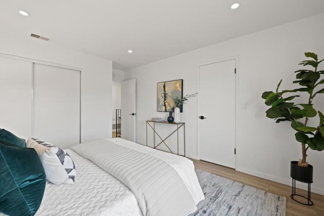 bedroom with light hardwood / wood-style flooring and a closet