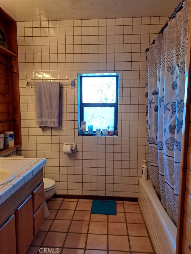 full bathroom with tile patterned floors, toilet, tile walls, vanity, and shower / bath combo