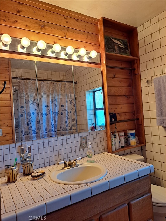 bathroom with walk in shower, vanity, and toilet