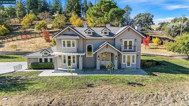 back of house featuring a yard and french doors