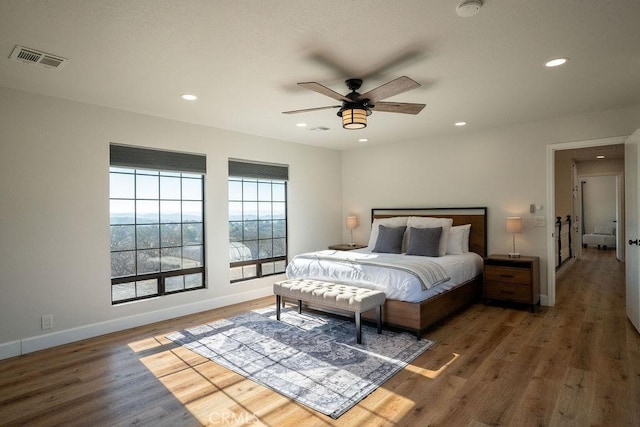 bedroom with visible vents, ceiling fan, baseboards, recessed lighting, and wood finished floors