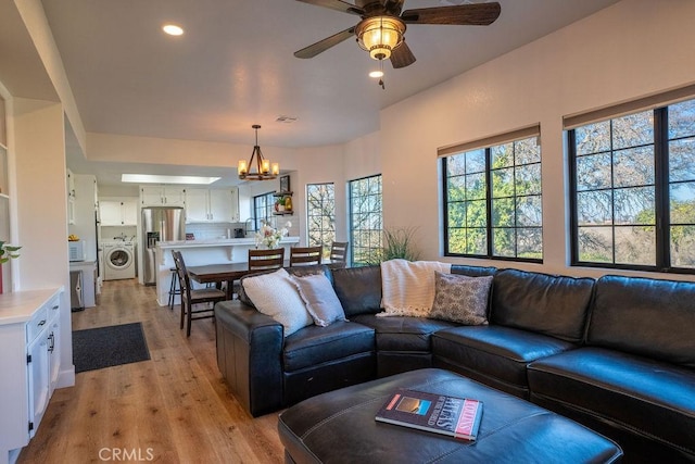 living area with visible vents, ceiling fan with notable chandelier, recessed lighting, light wood finished floors, and washer / dryer