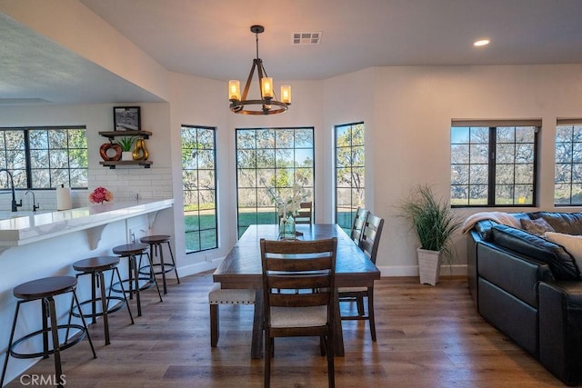 dining space with wood finished floors, baseboards, and a chandelier