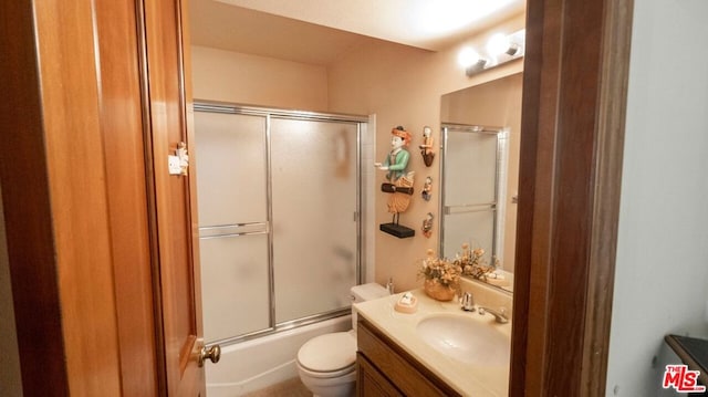 full bathroom with vanity, toilet, and combined bath / shower with glass door