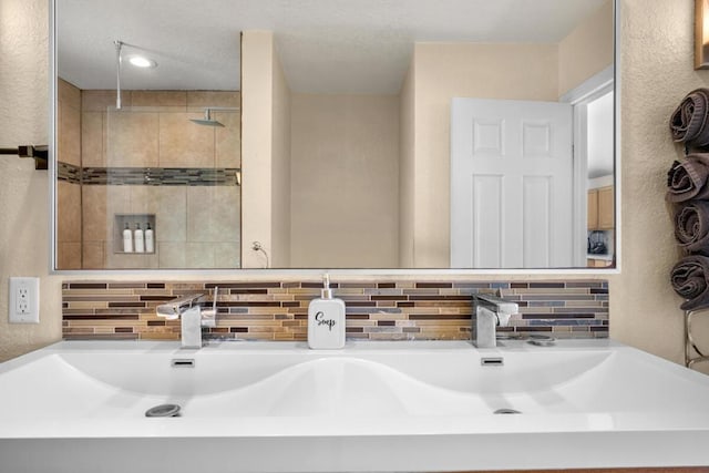 bathroom with tasteful backsplash, sink, and a shower