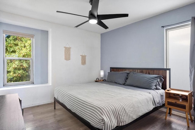 bedroom with dark hardwood / wood-style flooring and ceiling fan