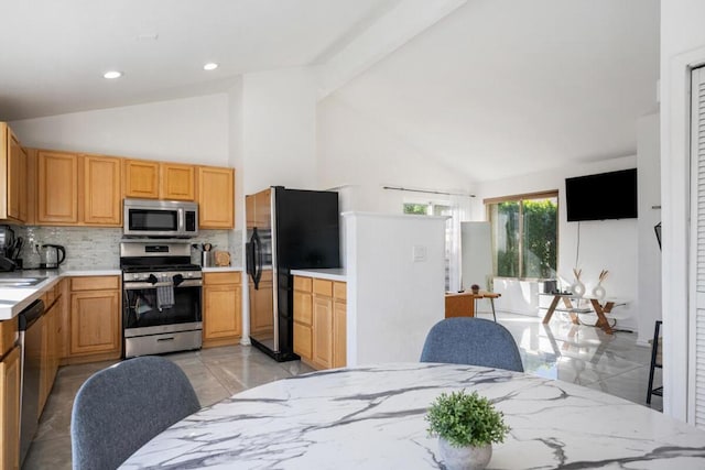 kitchen featuring stainless steel appliances, sink, high vaulted ceiling, and decorative backsplash