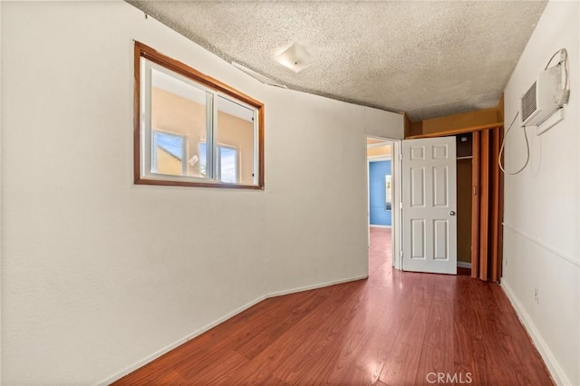 spare room with dark wood-type flooring and a textured ceiling