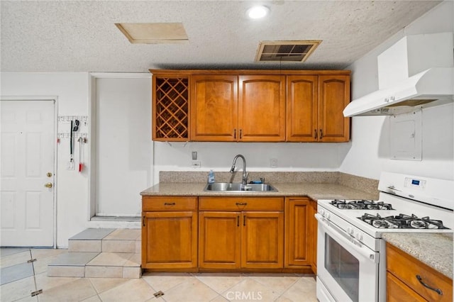 kitchen featuring light tile patterned floors, sink, white range with gas stovetop, a textured ceiling, and wall chimney exhaust hood