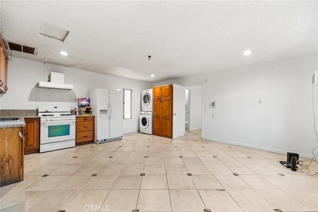 kitchen featuring stacked washer and clothes dryer, a textured ceiling, and white appliances