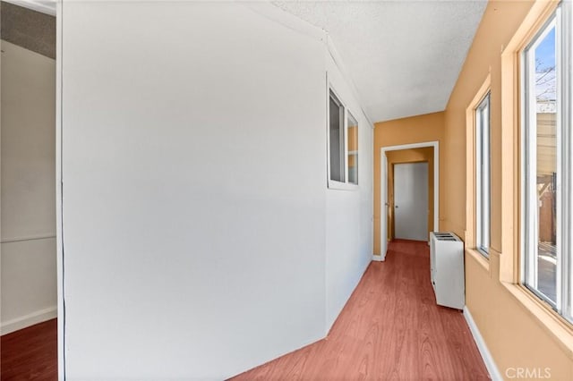 corridor featuring hardwood / wood-style flooring and a textured ceiling