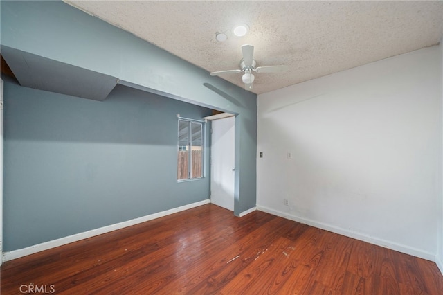 unfurnished room featuring dark hardwood / wood-style flooring, ceiling fan, and a textured ceiling