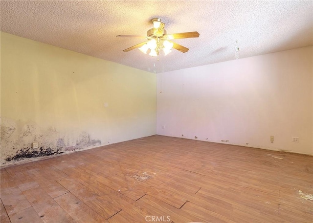 empty room featuring ceiling fan, a textured ceiling, and light wood-type flooring