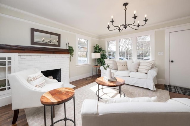 living room with a fireplace, wood-type flooring, ornamental molding, and a chandelier