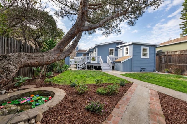 rear view of property featuring a deck and a lawn