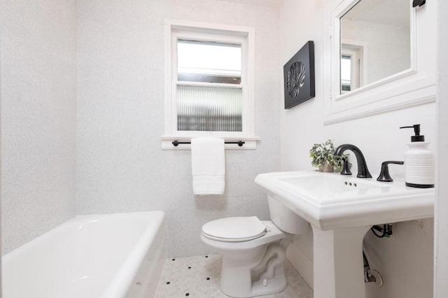 bathroom with a tub and toilet