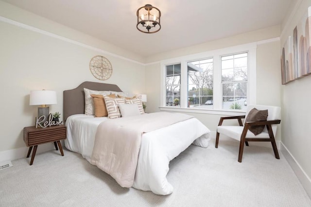 bedroom with light carpet and a chandelier