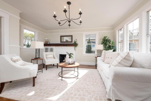 living room with hardwood / wood-style flooring, crown molding, a fireplace, and an inviting chandelier