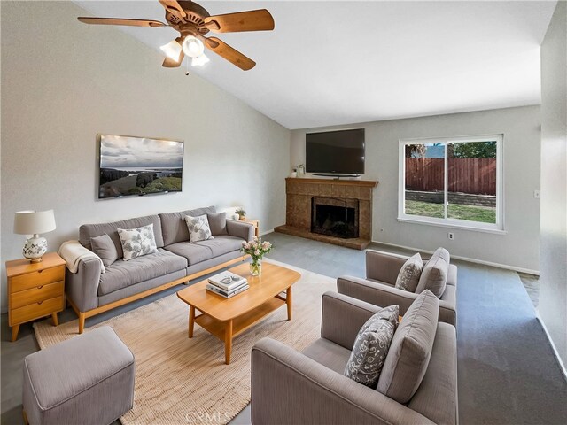 living room with ceiling fan, a fireplace, and vaulted ceiling