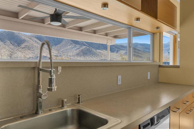 kitchen with a mountain view, sink, stainless steel dishwasher, and ceiling fan