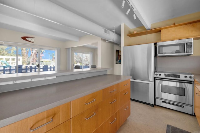 kitchen with track lighting, beamed ceiling, and appliances with stainless steel finishes