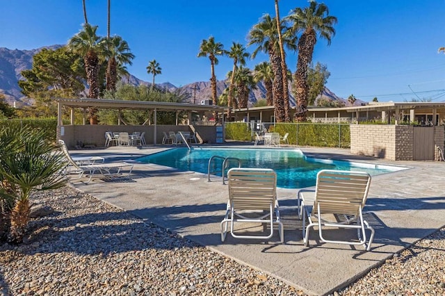 view of swimming pool with a mountain view and a patio