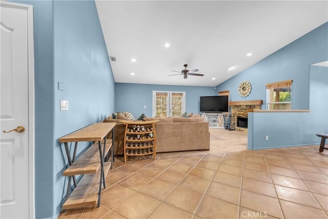 living room featuring ceiling fan, plenty of natural light, vaulted ceiling, and light tile patterned floors